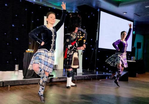 Bagpiper with Highland Dancers